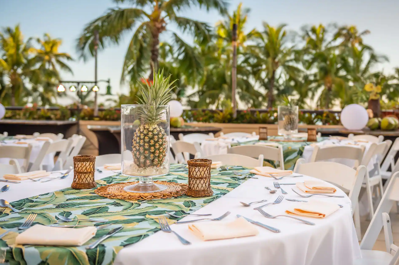 Elegant wedding tablescape at Hyatt Regency Waikiki with floral centerpieces and ocean views overlooking Waikiki Beach.
