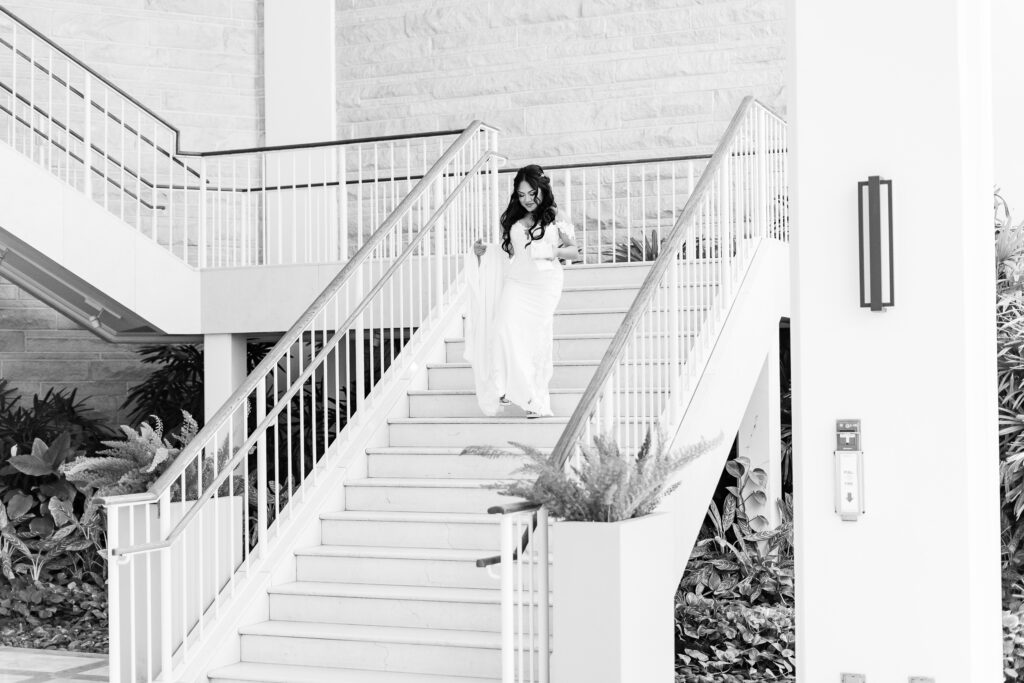 Bride carefully makes her way down the grand stairway at Royal Hawaiian Golf Club for her wedding.
