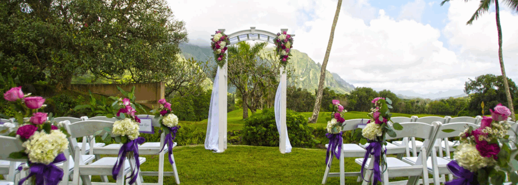 Wedding ceremony set up outdoors at Koolau Ballrooms, surrounded by lush greenery.